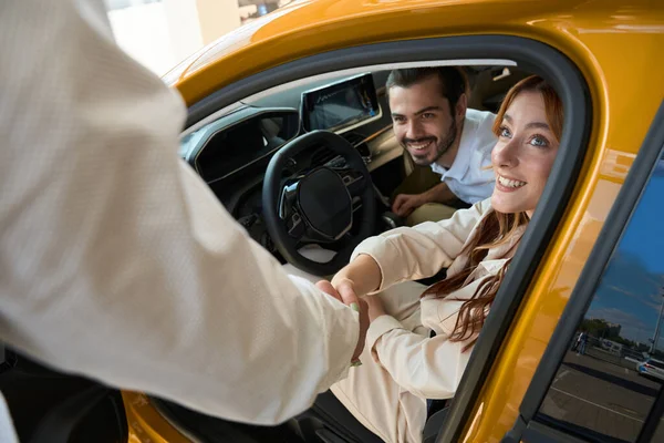 Salesperson Shaking Hands Joyful Female Client Seated Car Her Pleased — Stock Photo, Image