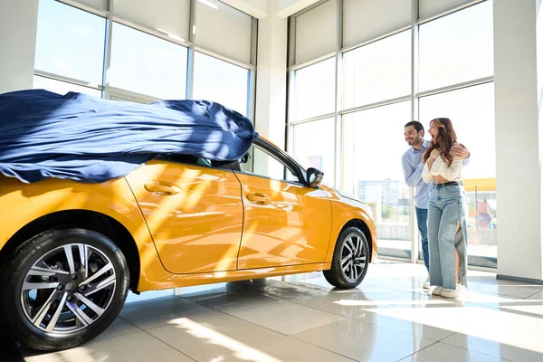 Smiling Man Presenting New Vehicle Delighted Young Woman Auto Showroom — Stock Photo, Image