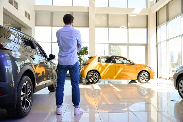 自動車販売における真新しい高級車の間での人間の立ち位置のバックビュー — ストック写真