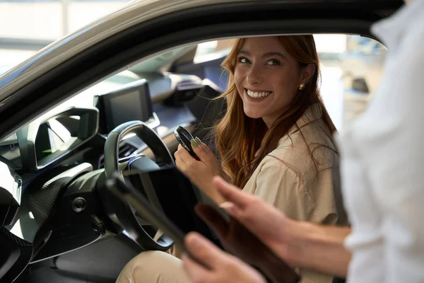 Γυναίκα Κλειδί Αυτοκινήτου Fob Κάθεται Στο Τιμόνι Και Κοιτάζοντας Πωλητής — Φωτογραφία Αρχείου