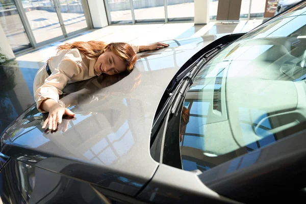 Sorrindo Comprador Feminino Caucasiano Feliz Deitado Capô Carro Auto Showroom — Fotografia de Stock