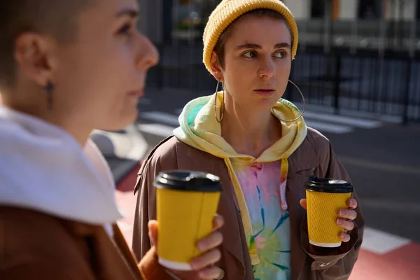 Dwie Kobiety Żółtych Okularach Drinkiem Przechadzają Się Ulicami Miasta Parą — Zdjęcie stockowe