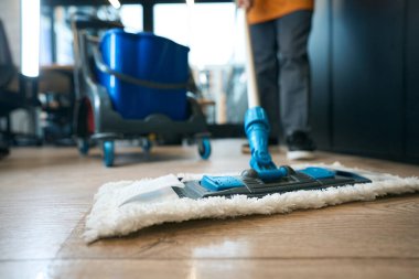 Cleaning services in the coworking area, workers use a mop, buckets, rags and a special cart clipart