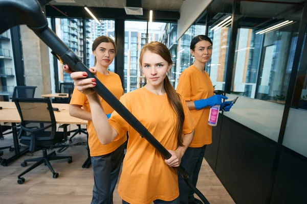 掃除機 ラグとスプレーで均一で保護手袋のクリーニングと消毒オフィススペースの3つの清掃会社の労働者 — ストック写真