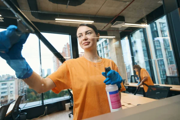 清掃サービス労働者は特別なガラススクレーパー 掃除機を使用し 作業服と保護手袋を着用しています — ストック写真