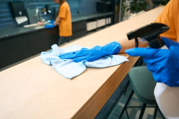 Cleaning company workers in uniform clean and disinfect surfaces, they use special gadgets
