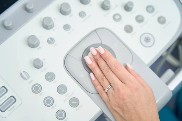 为了对病人进行超声波检查 妇女把她的手放在机器上 上面有一个整洁的 裸体的 彩色的指甲 — 图库照片