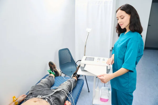 Mujer Relajada Realizando Procedimiento Electrocardiograma Mientras Hombre Yace Sofá Con — Foto de Stock