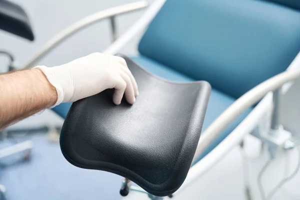 一名戴着无菌手套的医生的手调整检查女性椅子的细节 — 图库照片