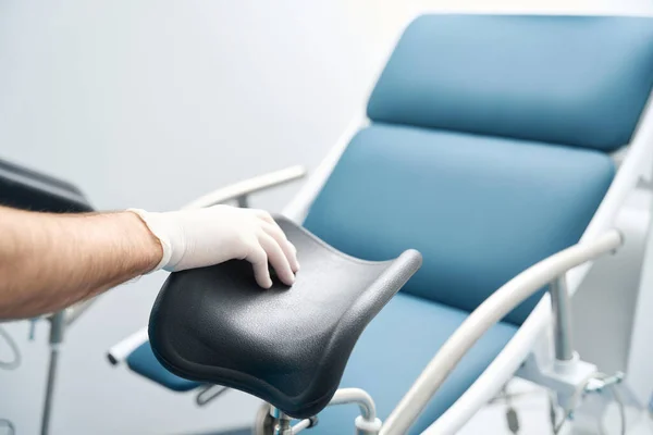 一名戴无菌手套的医护人员手摸到椅子检查病人 — 图库照片