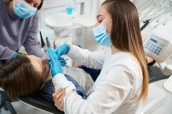 Mujer Dentista Quita Diente Paciente Joven Asistente Ayuda Trabajo —  Fotos de Stock