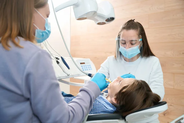Mujer Dentista Con Asistente Trata Diente Paciente Joven Médico Utiliza — Foto de Stock