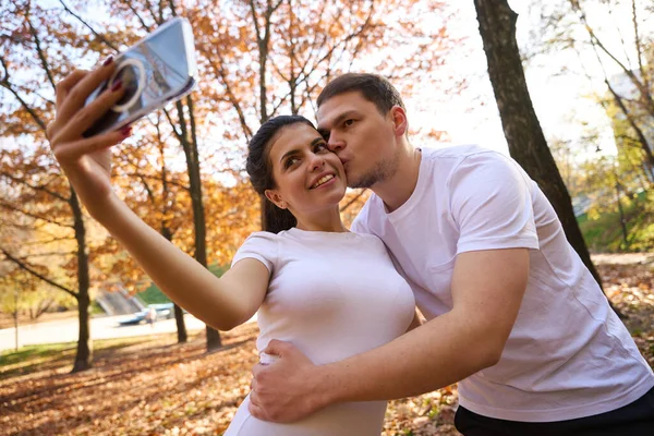 可愛い夫婦は秋の風景を背景にキスで自慰行為をします スポーツウェアの男 — ストック写真