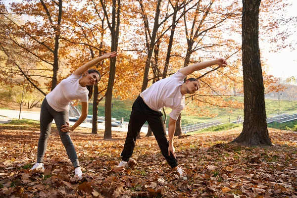 Jovens Alegres Fazem Exercícios Parque Cidade São Cercados Por Árvores — Fotografia de Stock