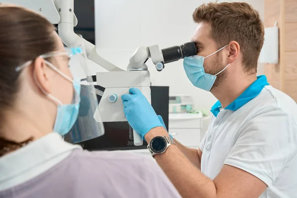 Estomatólogo Mirando Través Del Ocular Del Microscopio Dental Girando Perilla —  Fotos de Stock