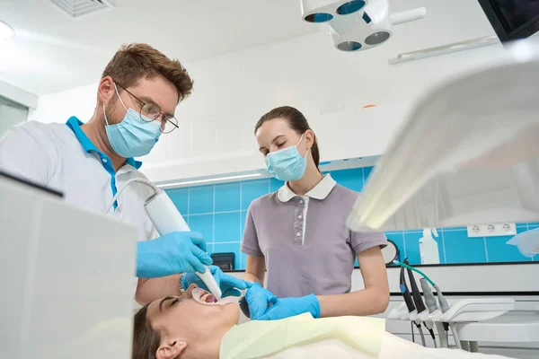 Odaklanmış Dişçi Asistanı Gözetiminde Tarayıcısı Olan Kadın Hastaların Dişlerini Tarıyor — Stok fotoğraf