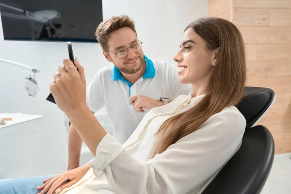 Glückliche Patientin Blickt Nach Zahnaufhellung Anwesenheit Eines Zufriedenen Stomatologen Den — Stockfoto