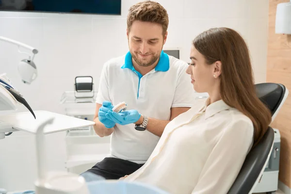 Odontólogo Sonriente Demostrando Dientes Delanteros Superiores Sanos Modelo Maxilar Cliente —  Fotos de Stock