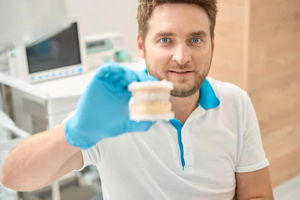 青年牙医在口腔一次性硝酸铵手套托架模型中的画像 — 图库照片