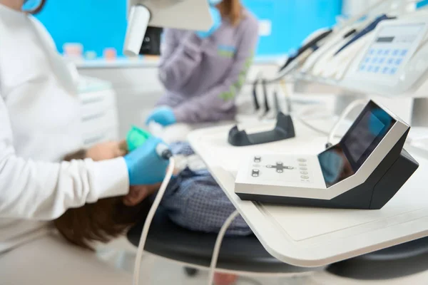 Dentista Trata Paciente Con Equipos Modernos Usa Microscopio Una Asistente — Foto de Stock