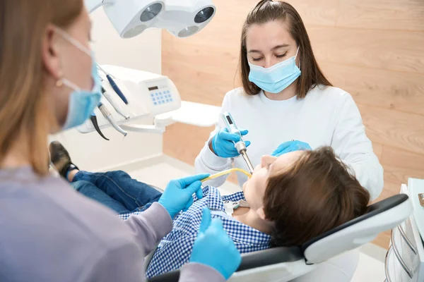 Mujer Dentista Lugar Trabajo Trabaja Con Paciente Joven Asistente Ayuda — Foto de Stock