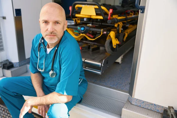 Aufgebrachter Arzt Blauer Uniform Sitzt Rand Einer Medizinischen Transportrampe Während — Stockfoto