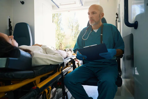 Médecin Attentif Est Dans Une Ambulance Pendant Une Femme Allonge — Photo