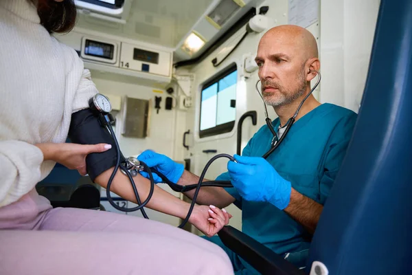 Besorgter Mann Beobachtet Blutdruckmessgerät Weiblicher Hand Während Sie Vor Ihm — Stockfoto