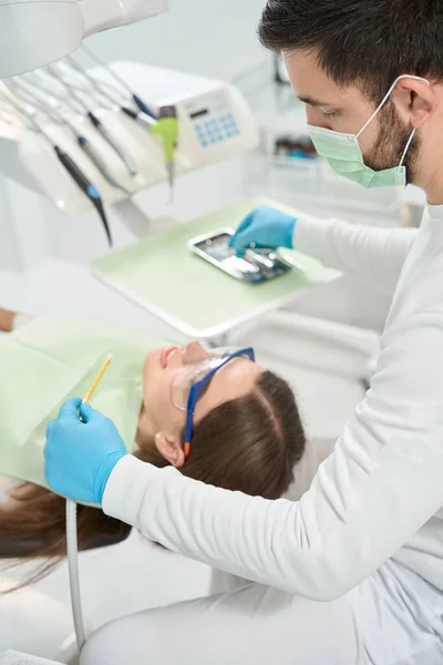 Dentista Olhando Para Paciente Tranquilo Deitado Cadeira Dentária Escolher Ferramenta — Fotografia de Stock