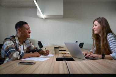 Ofisteki toplantı odasında birlikte çalışan mutlu iki iş arkadaşı.
