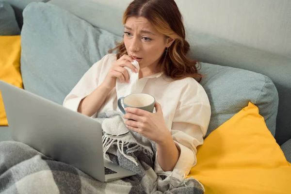 Upset Woman Seated Bed Handkerchief Mug Hands Staring Portable Computer —  Fotos de Stock