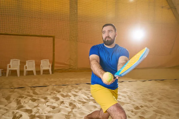 彼の視線がボールから離れて指示されている間 ラケットで運動中のテニスボールを打つしようとしているスポーツウェアの集中テニス選手 — ストック写真