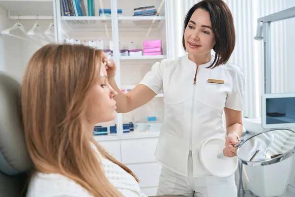 Employee Cosmetology Clinic Receiving Young Patient Woman Has Mirror Her — Foto de Stock
