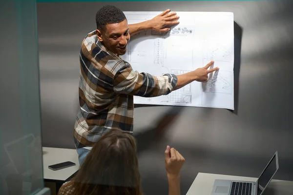 Smiling African America Man Showing Drawing His Female Colleague Meeting — Stockfoto