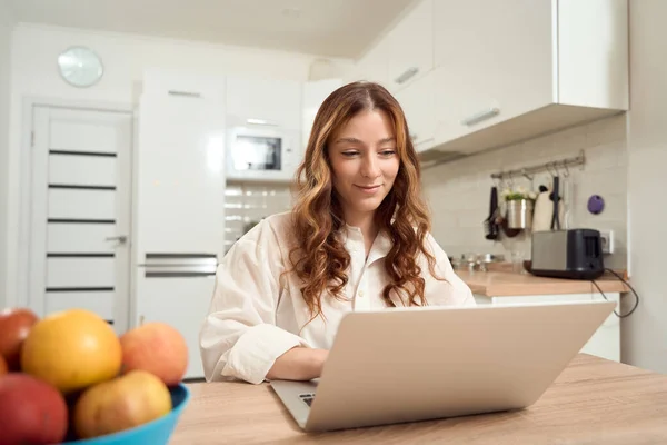 Smiling Female Sitting Table Kitchen While Looking Laptop Screen —  Fotos de Stock