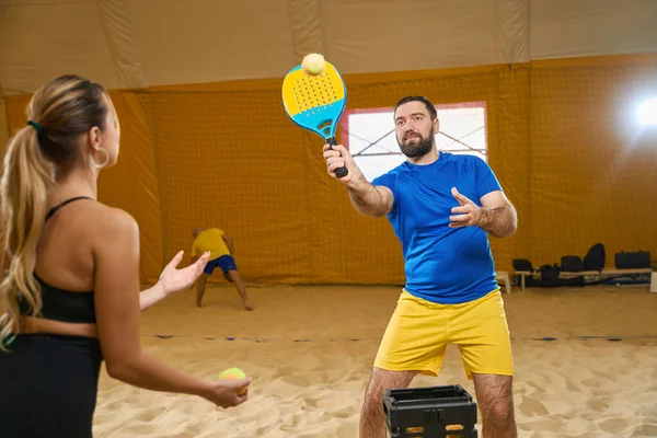 Enthusiastic Male Sportswear Holding Tennis Racket Hitting Ball While Partner — Zdjęcie stockowe