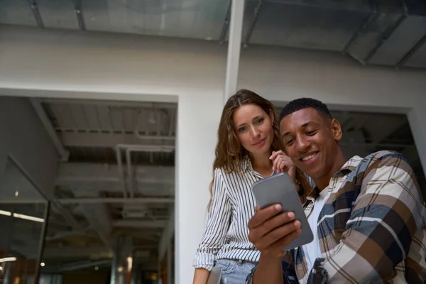 Smiling Two Colleagues Standing Looking Phone Screen Attentively Office — Stock Photo, Image