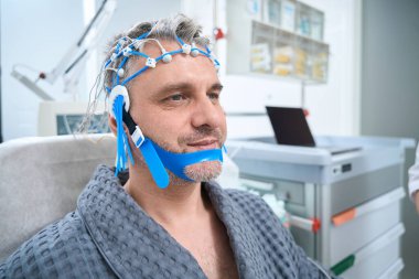 Patient in a medical clinic on an EEG - electroencephalography, sensors are attached to his head clipart