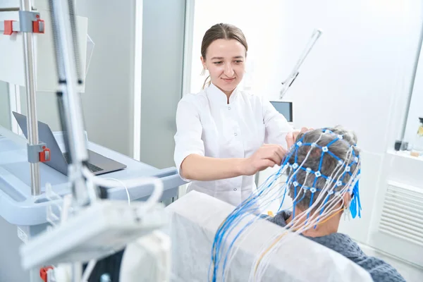 Woman Diagnostician Attaches Sensors Patient Head She Performs Eeg Electroencephalography — Stockfoto