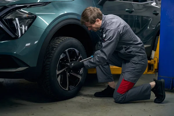 Mechanic Protective Clothes Sitting Automobile Tighten Bolt Monometric Wrench Tire — Stockfoto