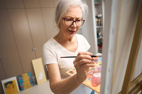 Talentosa Anciana Pinta Cuadro Una Habitación Luminosa Alrededor Sus Obras —  Fotos de Stock