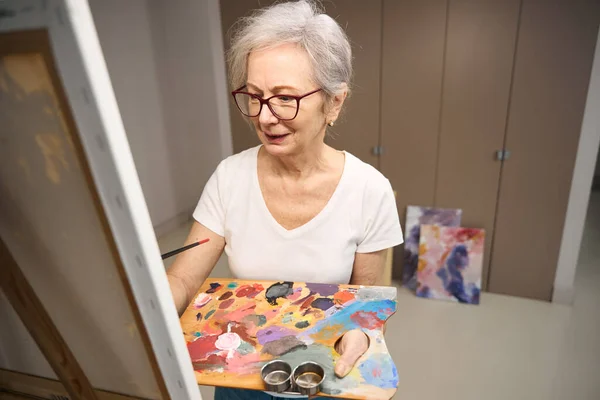 Pensioner Holds Palette Drawing Her Hands She Stands Front Easel —  Fotos de Stock