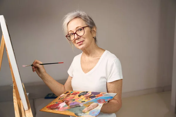 Gray Haired Sophisticated Lady Glasses Stands Front Easel She Paints —  Fotos de Stock