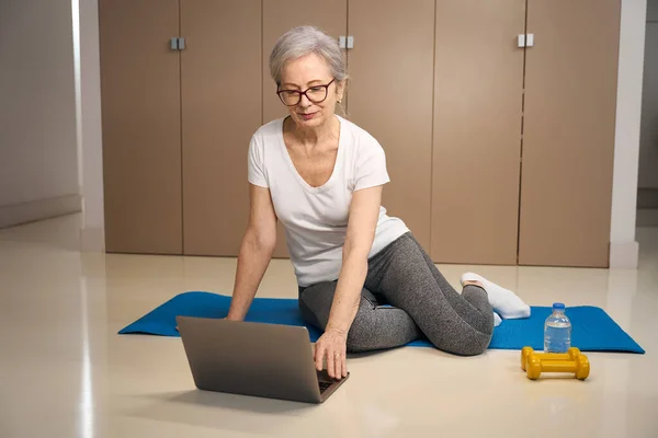 Elderly Lady Sits Carimat Front Laptop Water Dumbbells Sports — стоковое фото