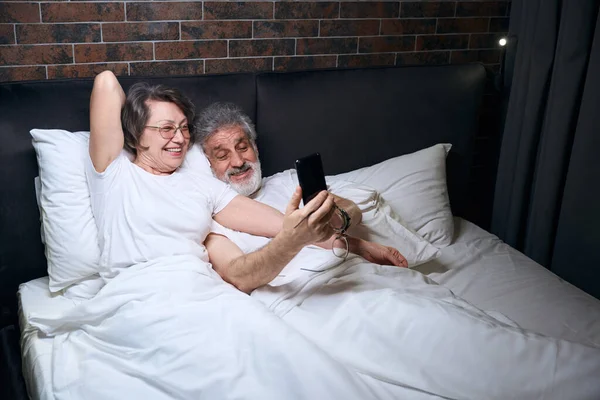 Femeie Vârstă Bărbat Întins Pat Dormitor Bărbat Care Deține Telefonul — Fotografie, imagine de stoc