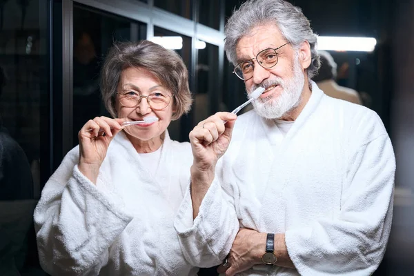 Elderly Female Male White Coats Standing Bathroom Holding Toothbrush Looking — Fotografia de Stock