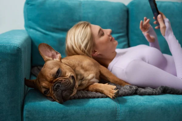 Sorrindo Satisfeito Fêmea Com Smartphone Mãos Deitado Seu Animal Estimação — Fotografia de Stock