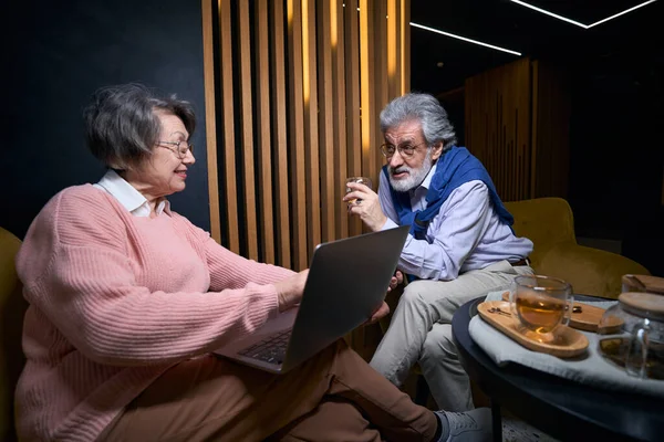 Mature Traveling Couple Chatting Hotel Lounge Area Woman Has Laptop — Stock Photo, Image