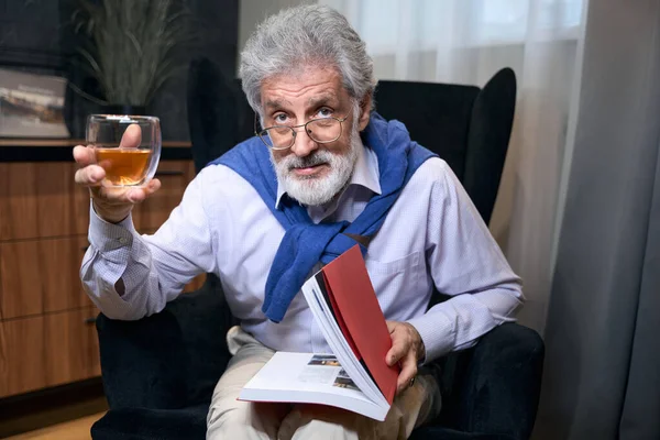 Solitario Abuelo Sienta Una Silla Acogedora Con Libro Una Bebida — Foto de Stock