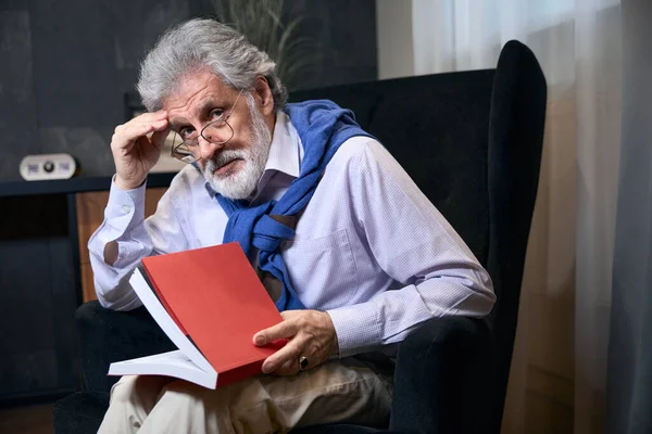 Yaşlı Erkek Rahat Bir Koltukta Elinde Bir Kitapla Oturuyor Şık — Stok fotoğraf